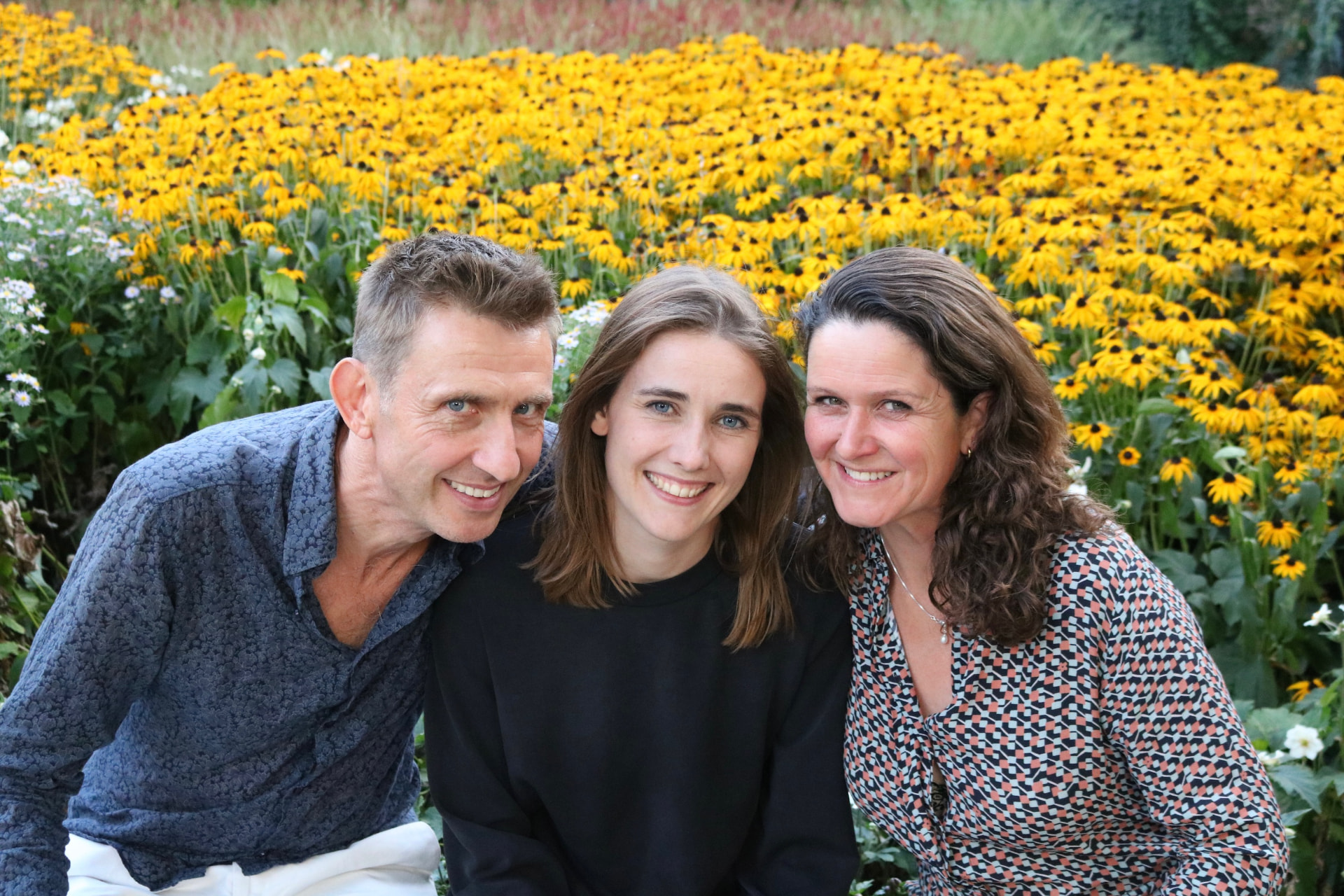Trio Martinot poseert samen in een bloemenveld